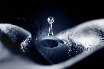 Close-up of water drop falling on metal