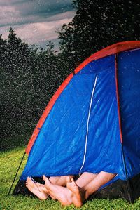 Low secti0on of people in tent on field during rainy season