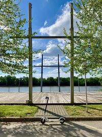 Empty bench in park against sky