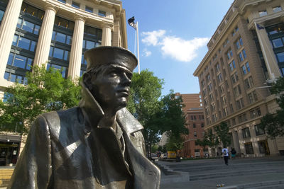 Statue against buildings in city