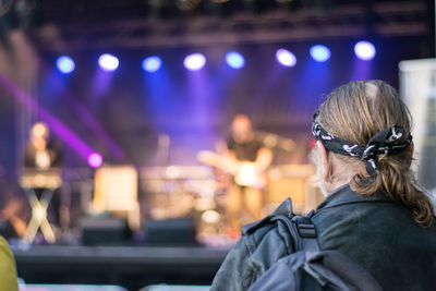 Rear view of man enjoying music concert