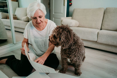 Woman with dog working on wood at home