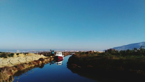 Scenic view of lake against clear blue sky