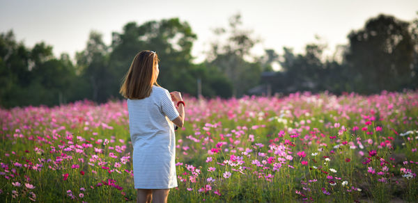 Woman standing against flowering plants