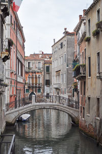 Bridge over canal amidst buildings in city