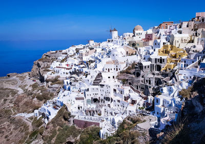 Aerial view of town by sea against clear blue sky