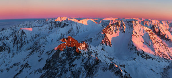 Scenic view of snow covered mountains during sunset