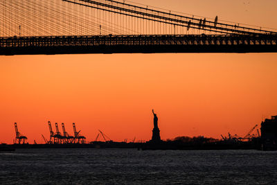 Low angle view of silhouette bridge against sky during sunset