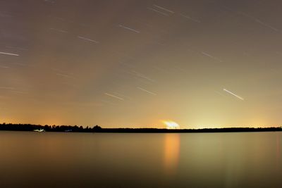 Scenic view of lake against sky at night