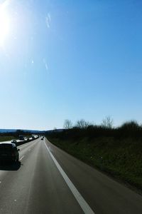 Cars on country road against sky