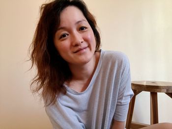 Portrait of woman sitting against wall