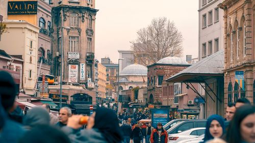 People on street amidst buildings in city