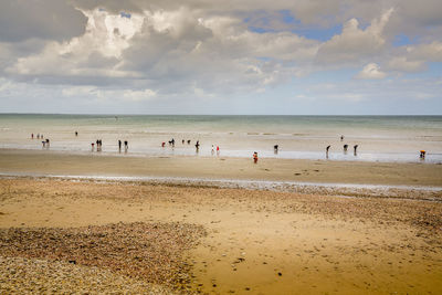 Group of people on beach against sky