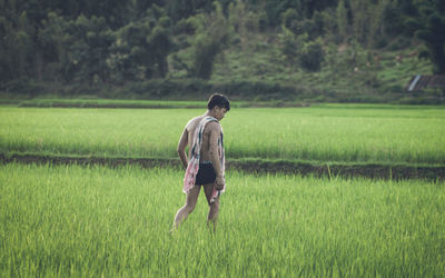 Rear view of woman standing on field