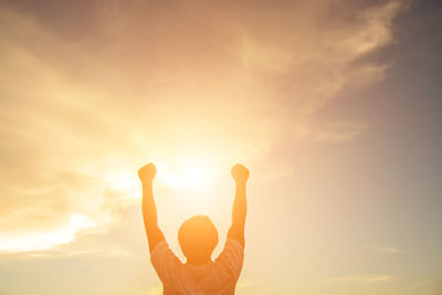 Silhouette man standing against orange sky