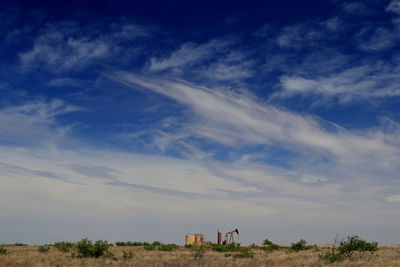 Scenic view of oil field against sky