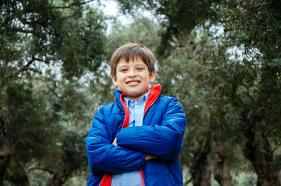 Portrait of happy boy standing in forest