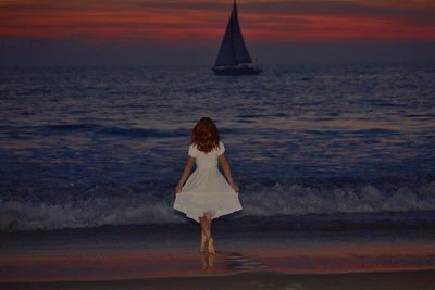 Rear view of woman standing on beach