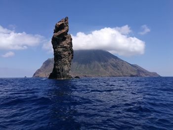 Rock formation in sea against sky