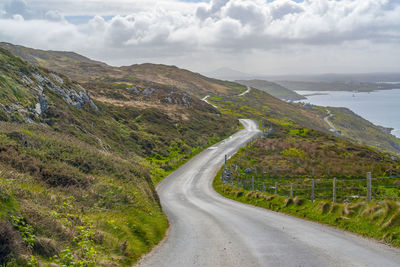 Road leading towards mountains against sky