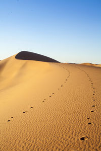 Scenic view of desert against clear blue sky