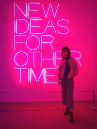 Full length portrait of man standing against illuminated wall