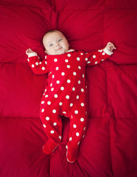 High angle view of baby girl lying on bed