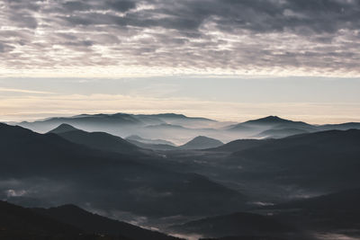 Scenic view of silhouette mountains against sky during sunset