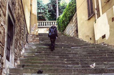 Rear view full length of woman moving up on steps