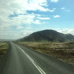 Empty road leading towards mountains