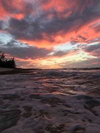 Scenic view of sea against dramatic sky during sunset