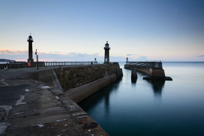 Pier on sea at sunset