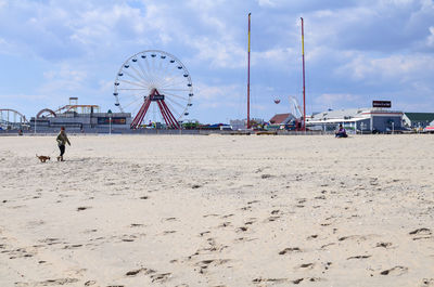 Ferris wheel on beach against sky