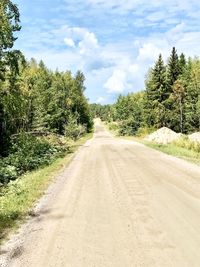 Road amidst trees against sky