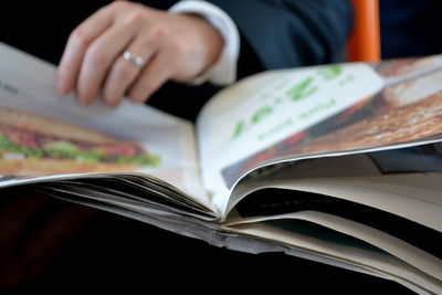 Close-up of cropped hand holding book