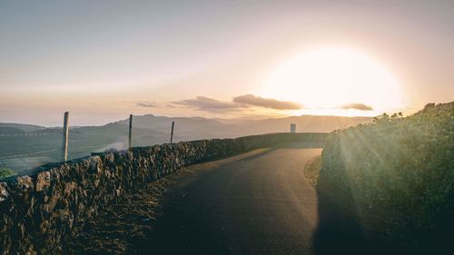 Scenic view of road against sky during sunset