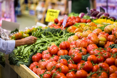 Cropped hand of man buying vegetables at market stall