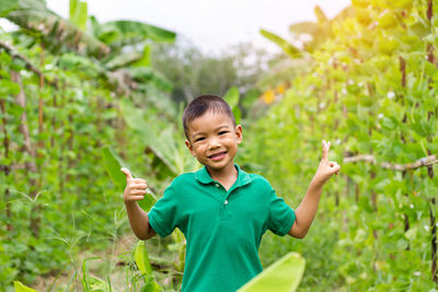 Portrait of happy boy gesturing while standing at farm
