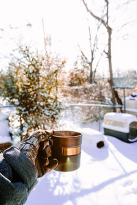 Coffee cup on table against trees