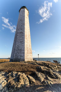 Lighthouse by sea against sky