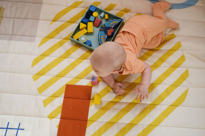 Infant on the floor of kids play room learning to crawl on the rug. early development. smiling baby