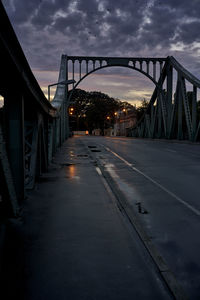 Bridge over road against sky at sunset