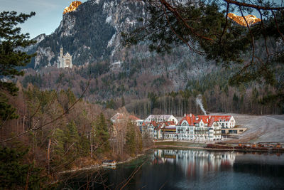 View of building by river against mountain