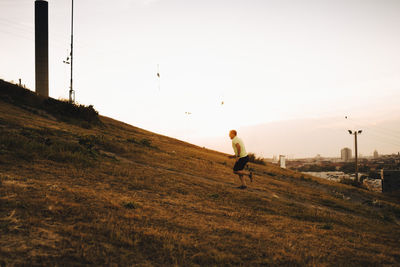 Sportsman running on land during sunset