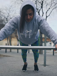 Full length of woman exercising on monkey bars