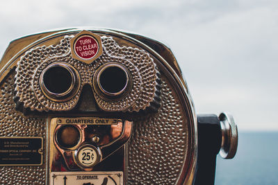 Close-up of coin-operated binoculars against sky