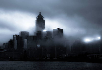 Buildings in city against cloudy sky