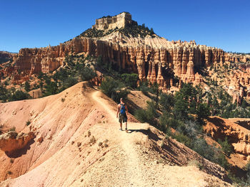 Panoramic view of man walking through the bryce canyon mountain against clear sky