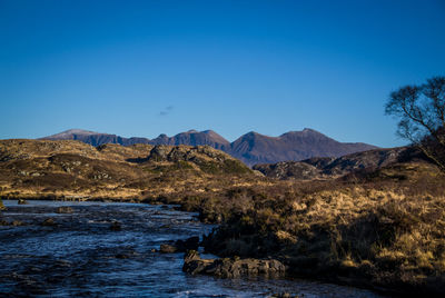 Scenic view of mountains against clear blue sky