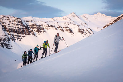 Group backcountry skiing in iceland with mountains